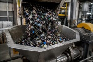 High impurity recycled plastic feedstock being fed into extrusion hopper