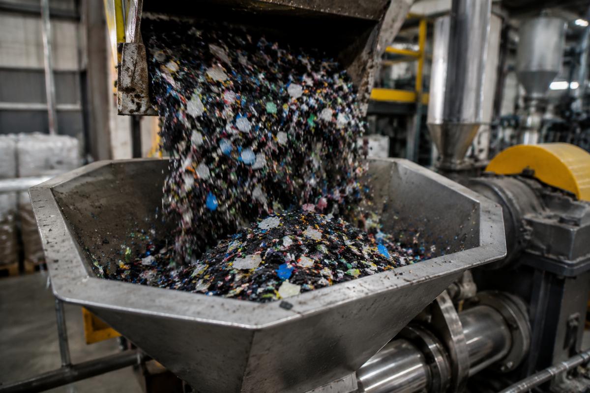 High impurity recycled plastic feedstock being fed into extrusion hopper